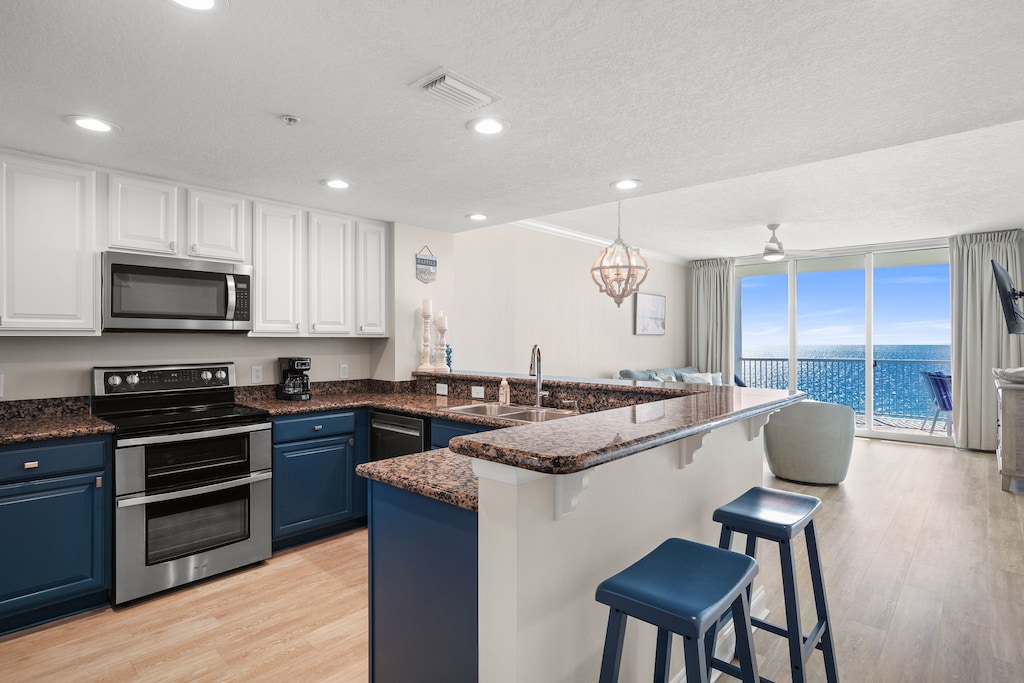 Cook with breathtaking ocean views in your spacious kitchen, featuring granite counters, breakfast bar seating, and floor-to-ceiling windows.