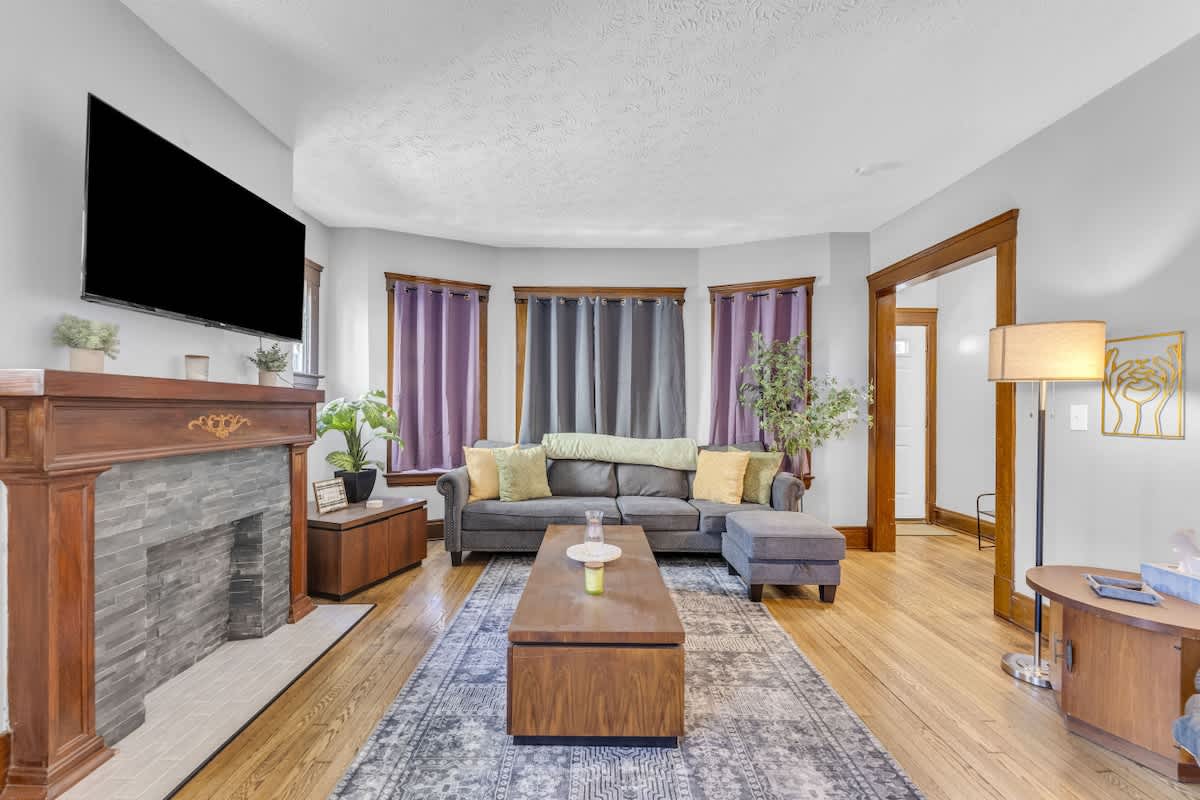 Inviting living room w/ sofa seating, TV & large windows letting natural light pour in