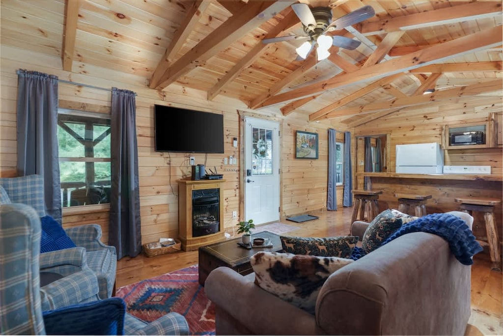 Cozy up in this charming living room w/ comfy seating, TV & bright windows letting in natural light