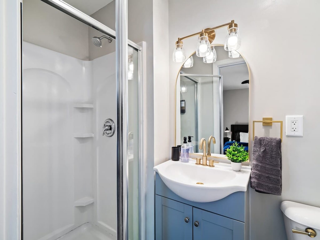 
Newly renovated bathroom featuring a chic blue vanity, brass fixtures, a modern mirror, and a full walk-in shower. 🚿💙