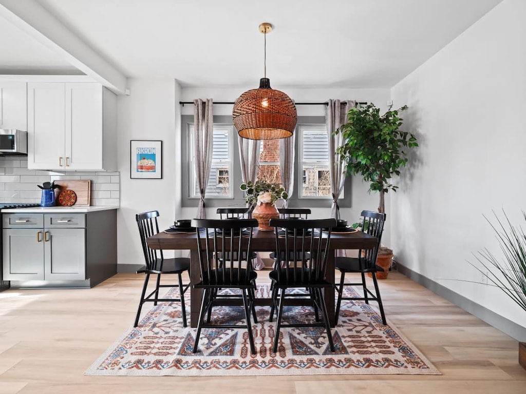 - Dining area with rustic wooden table and chairs   - Stylish woven pendant light over dining setting   - Warm accents with natural light and greenery  