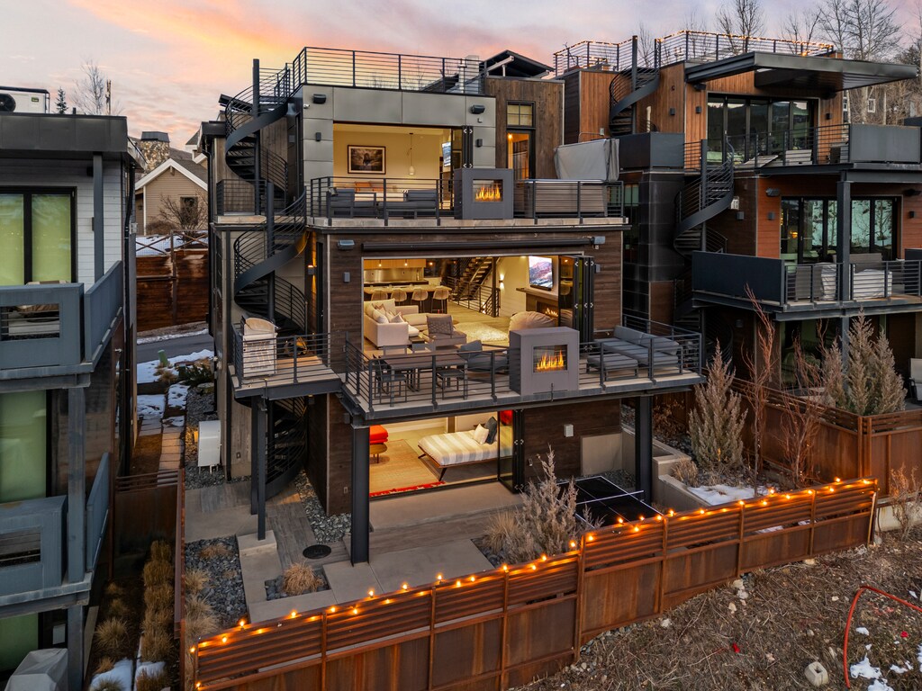 Contemporary mountain residence featuring modern architecture with warm lighting and multi-level design in scenic neighborhood setting.