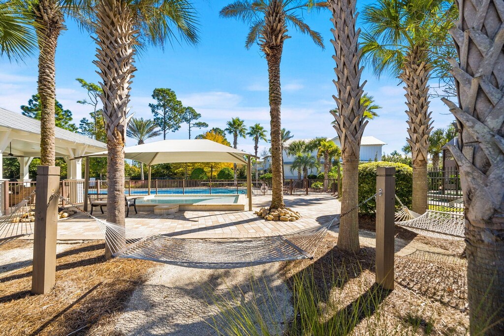Tropical paradise awaits with swaying palms, relaxing hammocks, and sparkling pool - your perfect coastal escape.