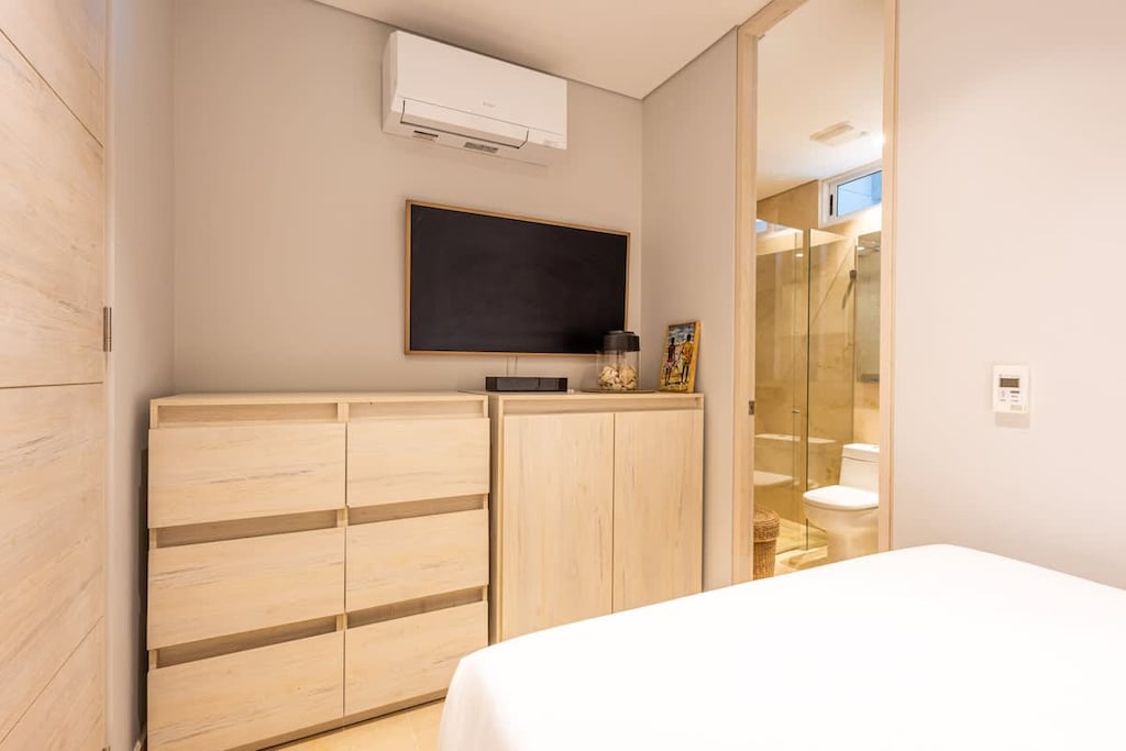 - Bedroom with TV setup and organized storage cabinetry  
- Neutral tones and warm lighting create a calm retreat  
- Ensuite access offering comfort and convenience  
