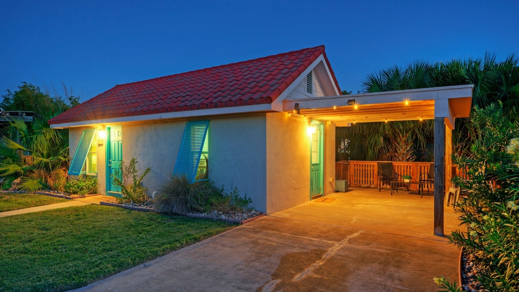 Charming coastal cottage with a cozy, well-lit patio perfect for relaxing after a day at the beach.