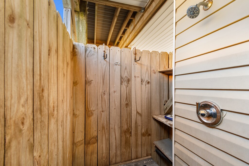 Step into your private outdoor shower, where natural wood surrounds you as you refresh under the open sky.