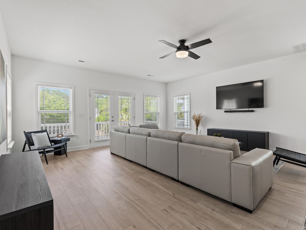 Unwind in your bright living space featuring plush seating, modern entertainment, and French doors opening to your private balcony.