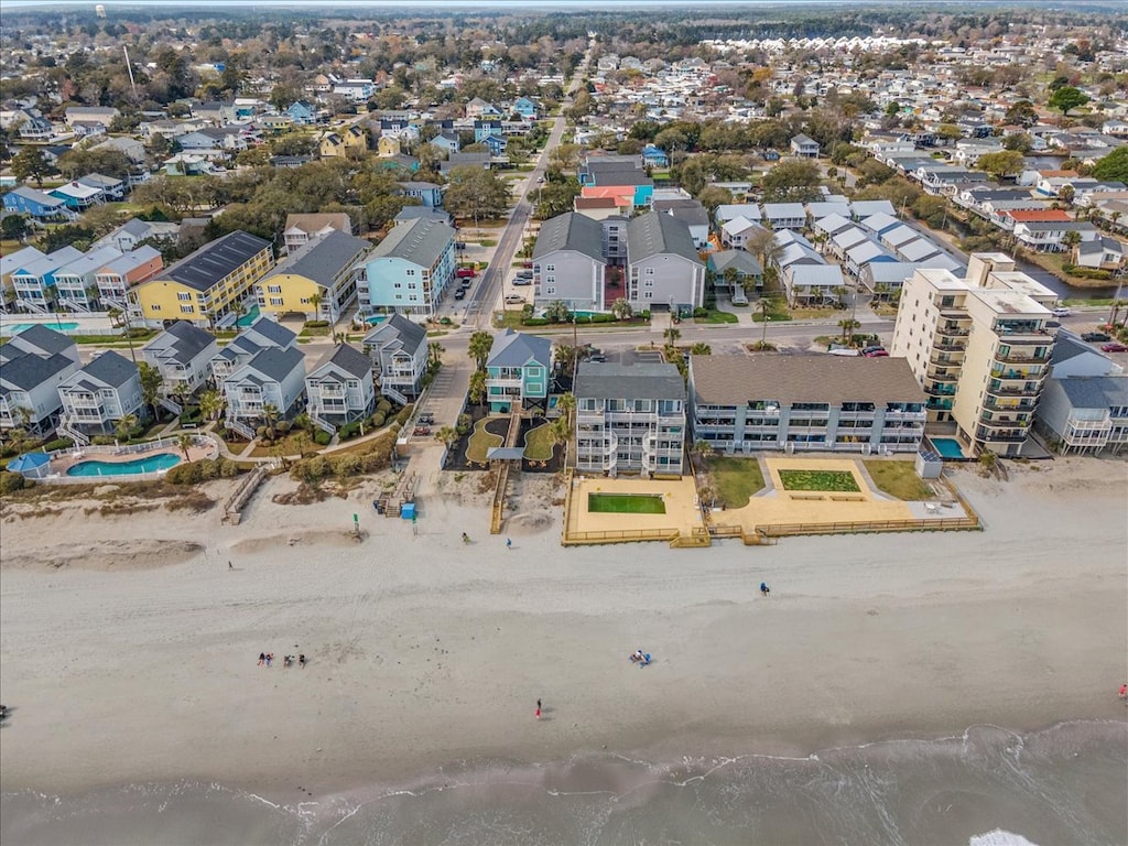 Aerial view showcasing beachfront vacation rentals with direct beach access in a charming coastal neighborhood.