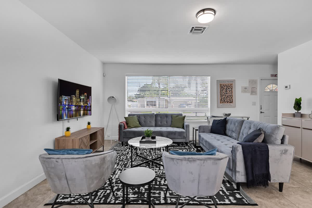 “Spacious living room with sectional sofa and flat-screen TV—perfect for unwinding at your vacation rental.”