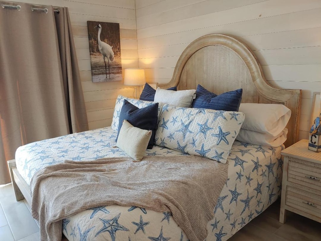 Sink into your coastal-themed bedroom with starfish linens and soft lighting creating the perfect seaside retreat for peaceful nights.
