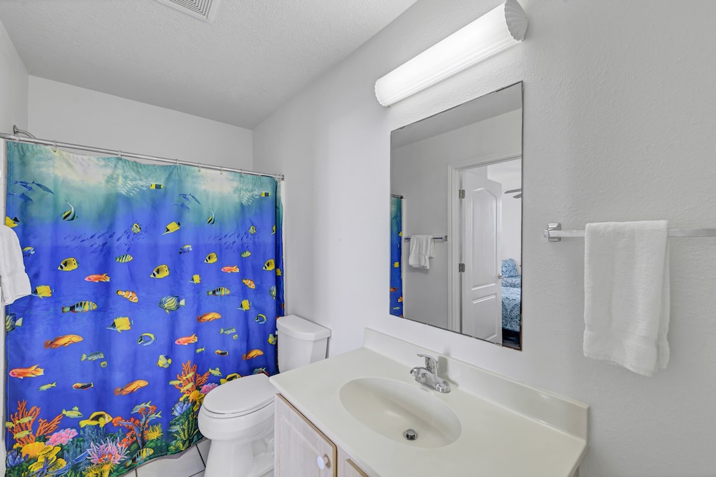 Dive into tropical vibes in your bright bathroom featuring a vibrant underwater-themed shower curtain that transforms your daily routine into an aquatic escape.
