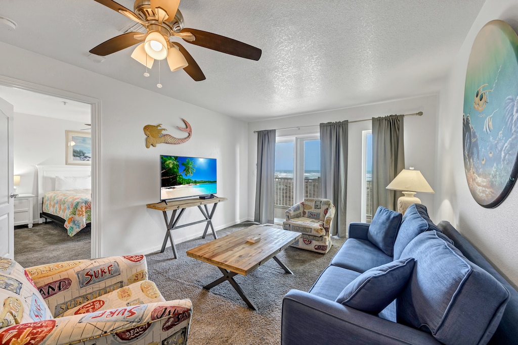 Relax in your coastal-themed living room with ocean views through your private balcony doors.