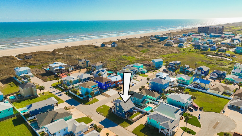 Coastal community with beachfront access and residential neighborhood featuring colorful homes near pristine sandy shoreline.