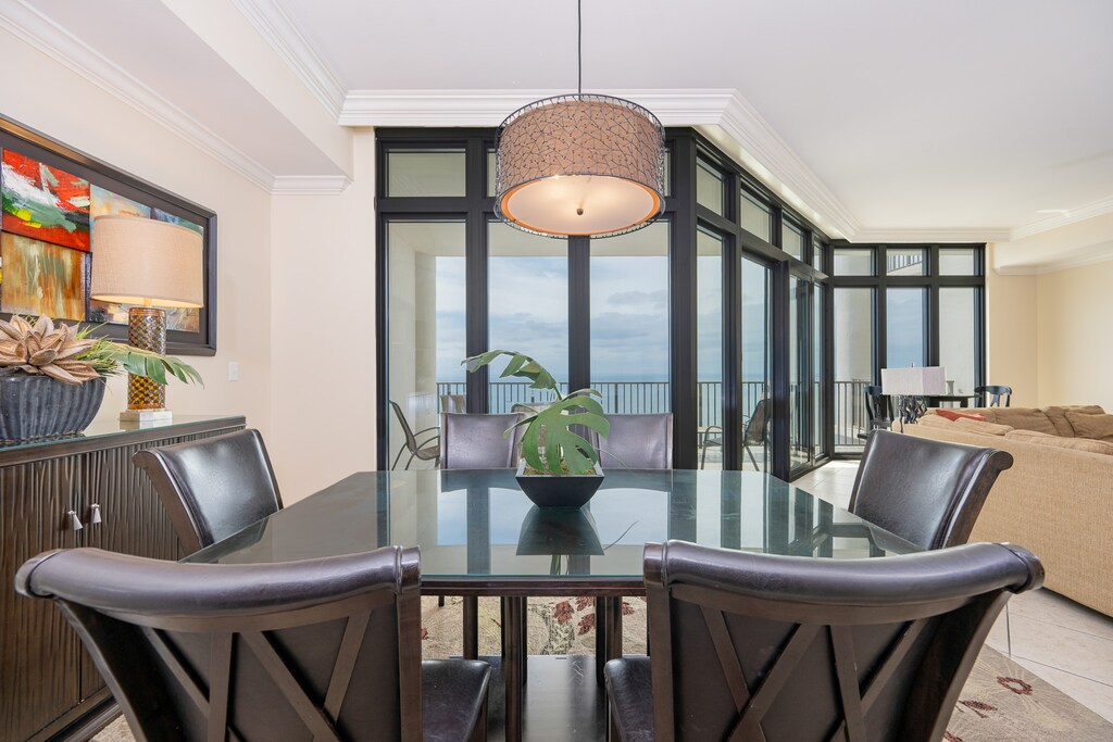 Bright dining area with sleek black chairs and a stunning view through expansive windows, perfect for memorable meals