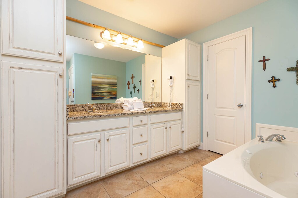 The master bath features a stylish granite countertop, cozy decor, and a relaxing jetted tub for a refreshing experience