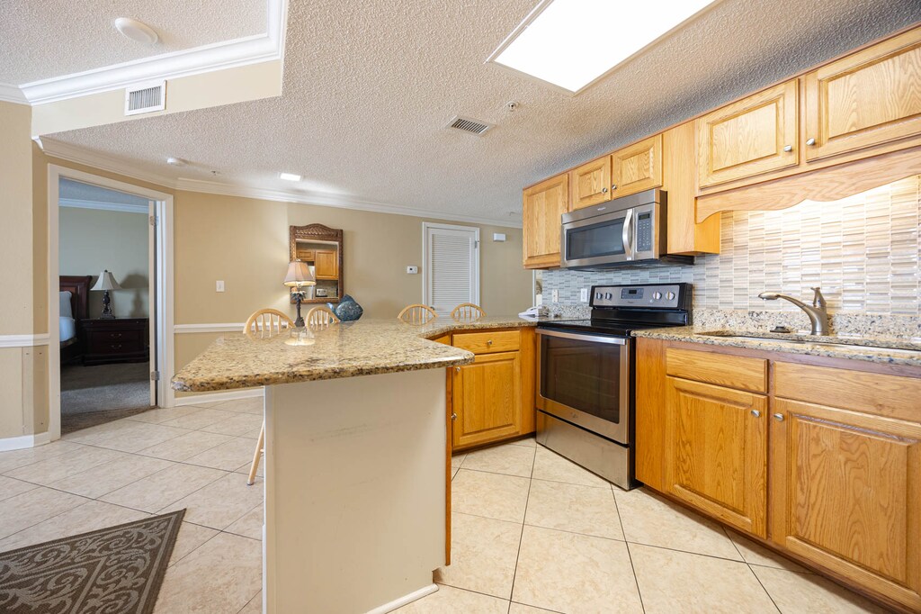 Prepare meals in the spacious kitchen featuring granite countertops, stainless appliances, and a breakfast bar