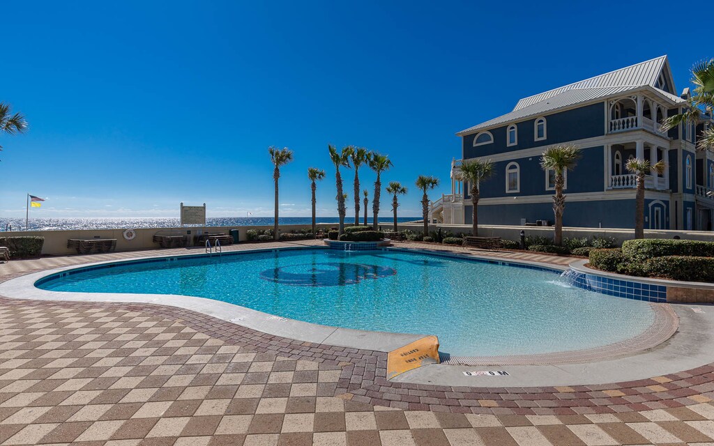 Discover the grandual entry pool at Phoenix West in Orange Beach, surrounded by swaying palms and inviting outdoor spaces
