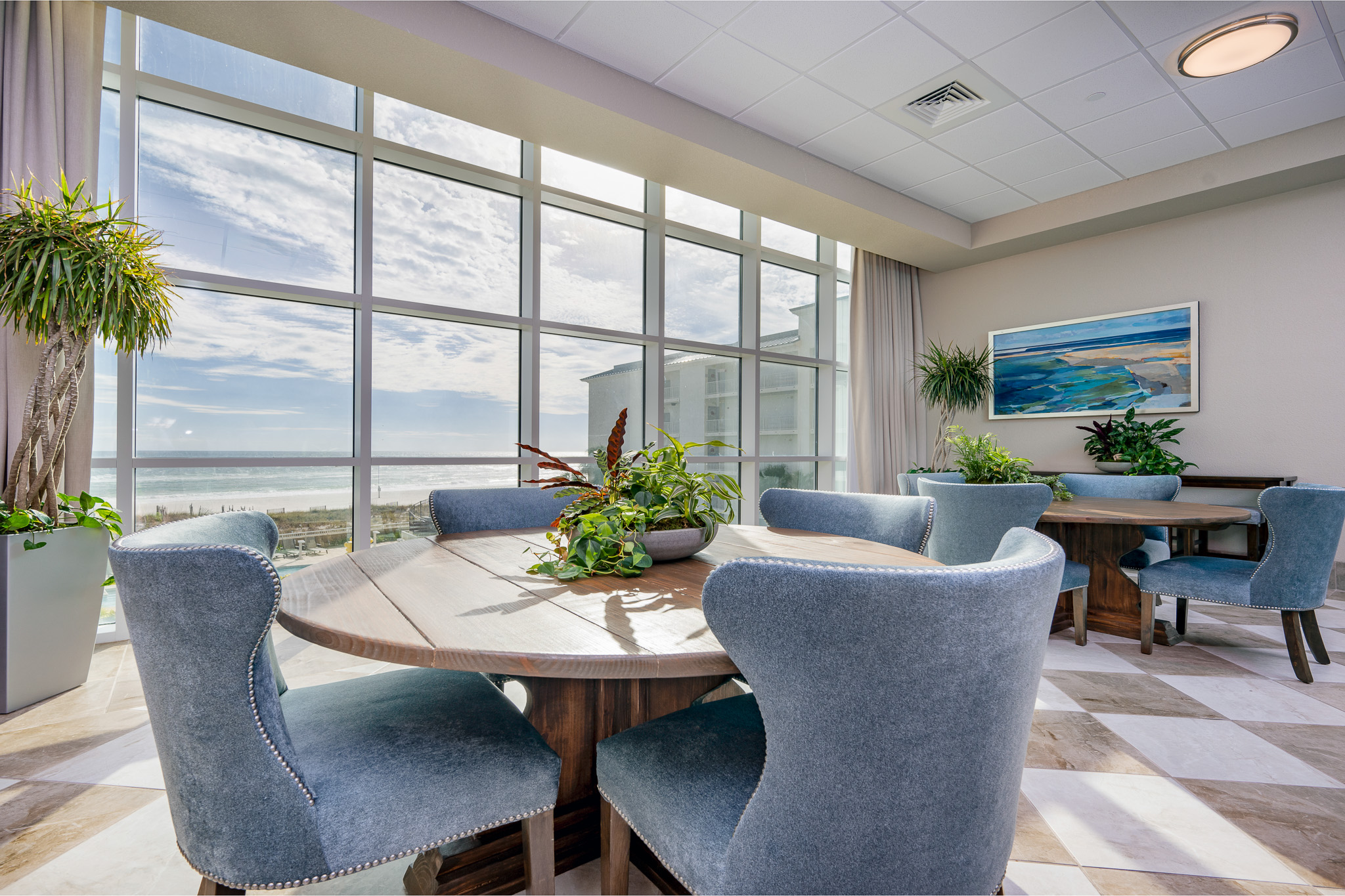 Relax in this bright lobby area with stunning beach views and lush greenery, perfect for gathering with friends and family