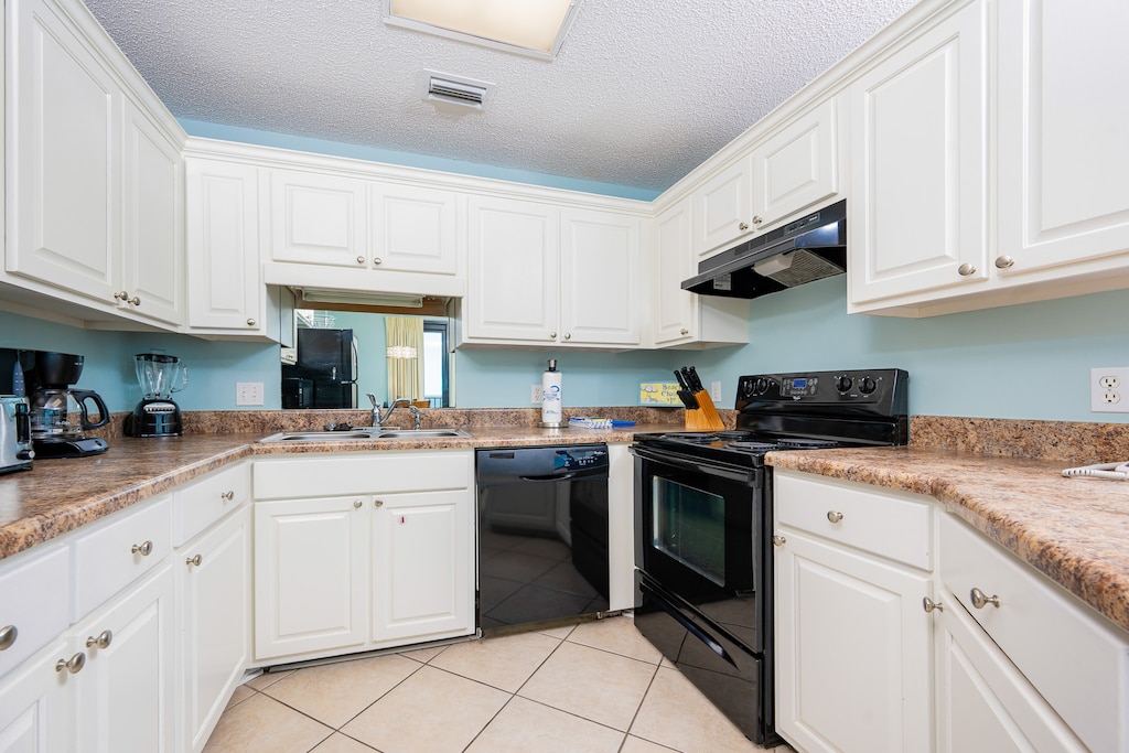 Bright and airy kitchen features sleek black appliances, ample counter space, and a cozy breakfast bar for casual dining