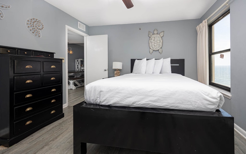 This cozy guest bedroom features a sleek black queen bed, ample storage, and a lovely view through the window