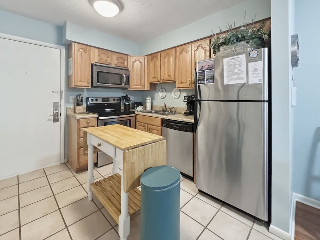 It includes wood cabinetry and stainless steel appliances.