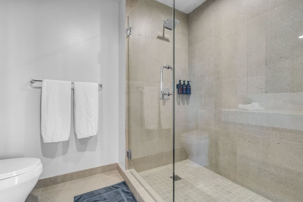 Modern bathroom featuring a spacious double vanity and a glass walk-in shower.