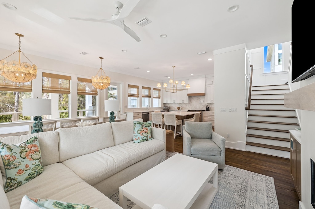 Sink into plush sofas in your bright, open living space where elegant fixtures and warm wood floors create the perfect retreat.