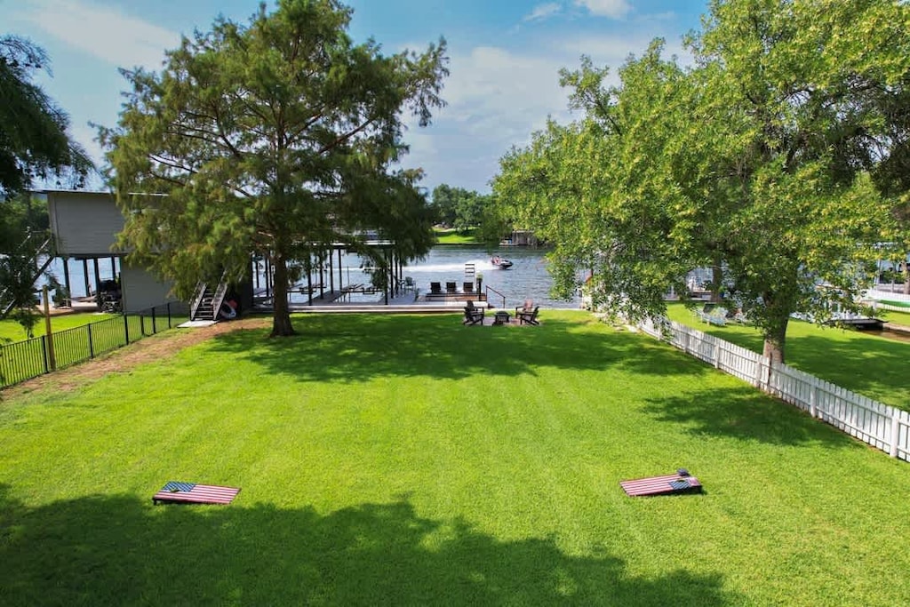 A small gate  leads to the rest of the yard with bag toss, a fire pit, and a 2-slip boat dock + 2 space jet ski ramp. 
