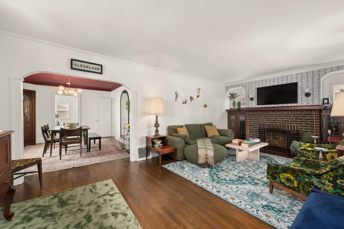Bright living room w/ cozy seating, TV & large windows letting in plenty of natural light