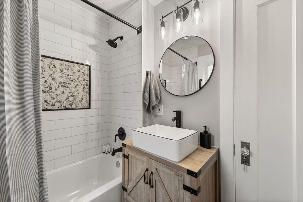 Pamper yourself in our second-floor bathroom, showcasing a sophisticated tub-shower combination and a sleek sink.