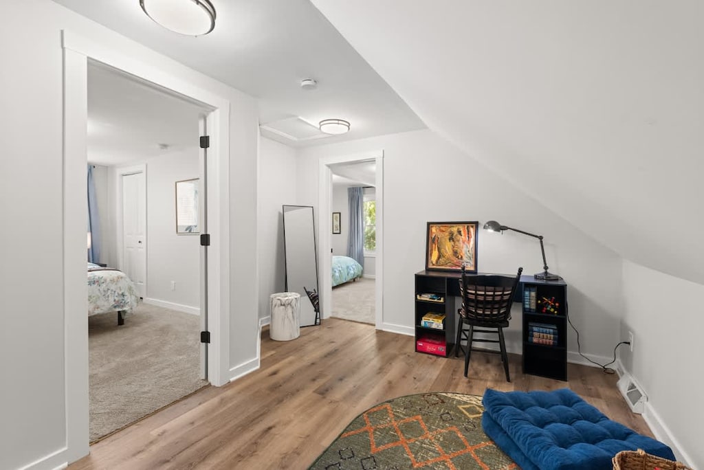 Discover the beauty of simplicity in this attic room, characterized by a stunning wooden floor and a touch of color with the elegant. A serene sanctuary for work and reflection. 