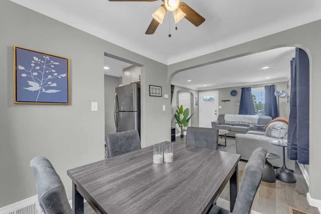 - Dining space flows into living room with archway design   - Modern table setup with seating for family or group meals   - Natural light enhances open concept living and dining area  