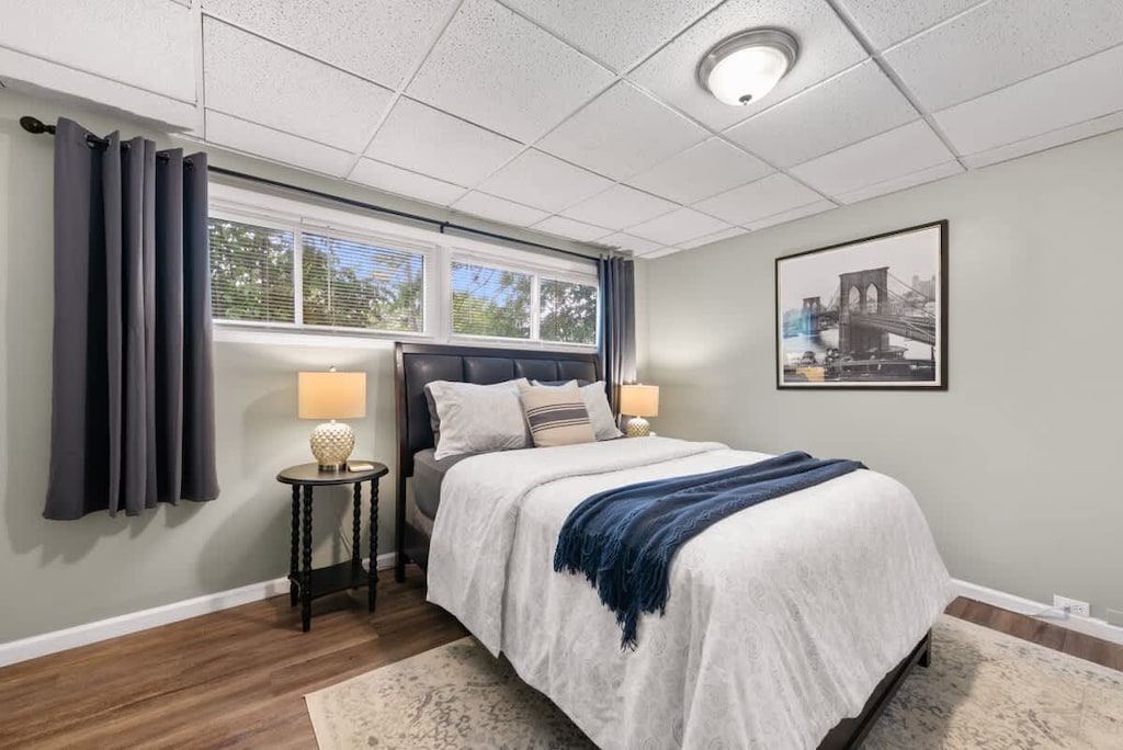Peaceful bedroom w/ soft bedding, large windows & gentle natural light for a restful stay