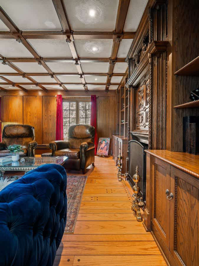 Elegant hallway w/ wood beams, paneled walls & warm natural light.