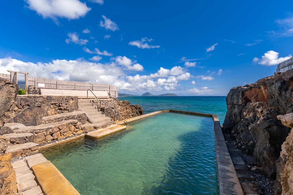 Natural ocean pools carved into volcanic rock create a unique swimming experience with crystal-clear waters and dramatic coastal views.