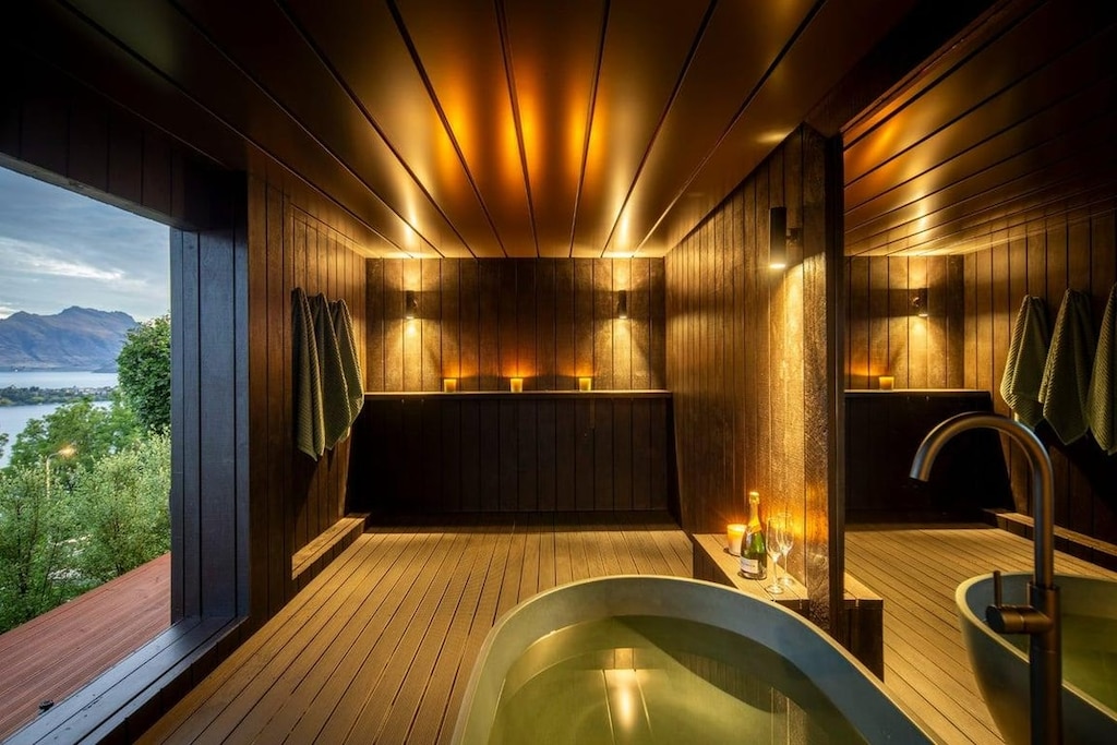 Indulge in a luxury soak with champagne and candlelight, overlooking Lake Wakatipu and the surrounding mountains.