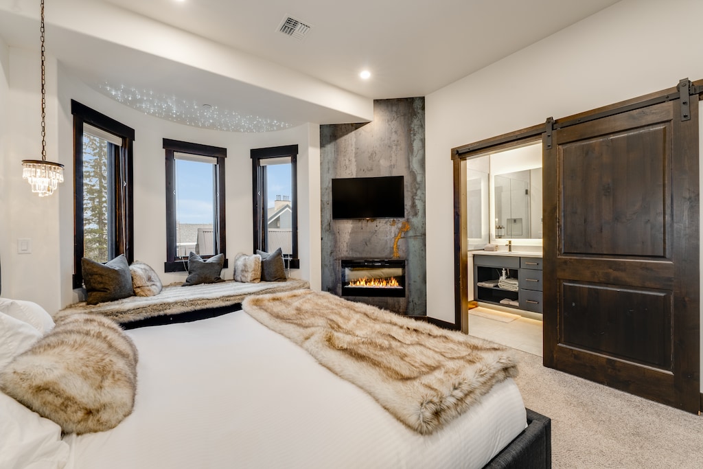Primary bedroom with fireplace and TV. | Main Level