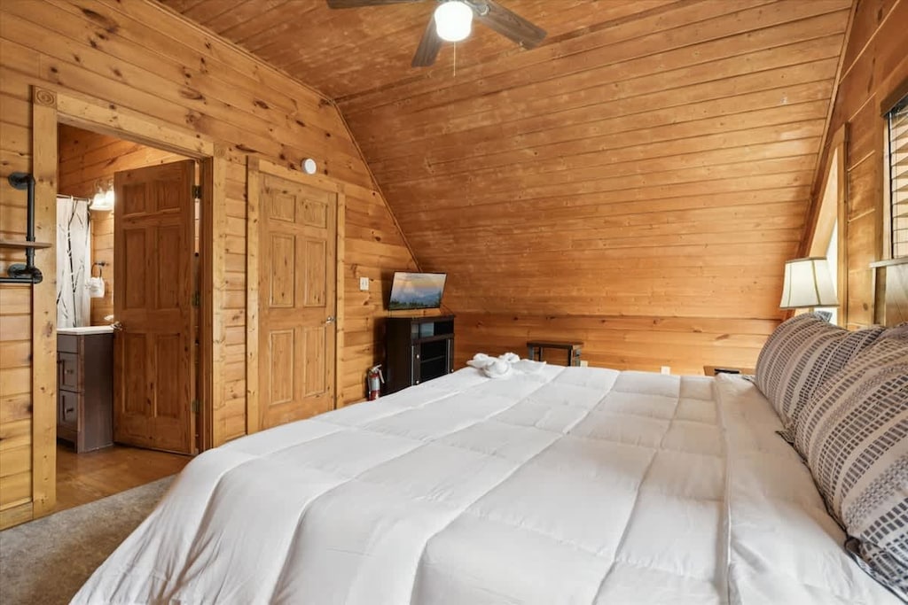 Bedroom Retreat: Experience rustic charm with wooden walls, plush bedding, and a relaxing vibe!