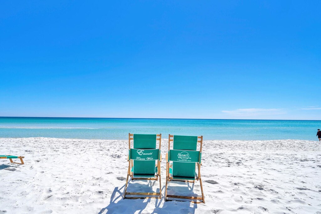 Pristine white sand beach with turquoise waters stretching endlessly under brilliant blue skies.