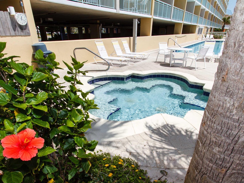 Soak in the bubbling hot tub surrounded by tropical plants and white lounge chairs at the Pelican Isle community pool
