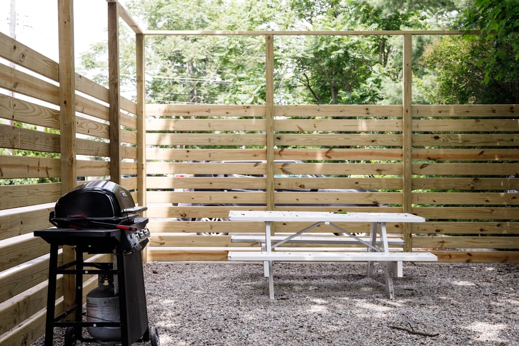Private fenced patio w/ grill & gravel lounge area for relaxed outdoor evenings.