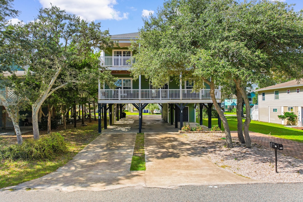 A charming elevated beach house nestled among mature oak trees, offering coastal comfort in a peaceful residential neighborhood.