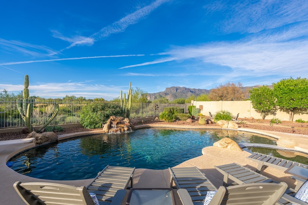 Unwind poolside with mountain views and desert charm. Your private oasis features lounge chairs, natural rock accents, and a serene landscape framed by Sonoran cacti.