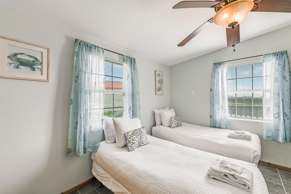 Drift off to sleep in your peaceful twin bedroom, where soft coastal curtains and crisp linens create the perfect seaside retreat.