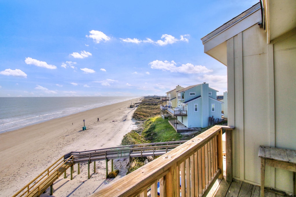 Stunning oceanfront view from your private balcony, where endless beach stretches meet blue sky—your perfect coastal retreat awaits.