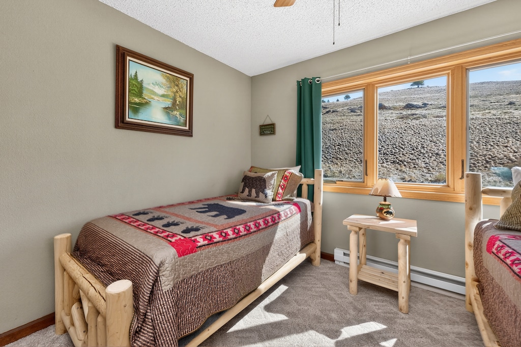 Cozy twin beds with rustic charm await in your peaceful retreat, complete with natural wood furnishings and stunning landscape views.
