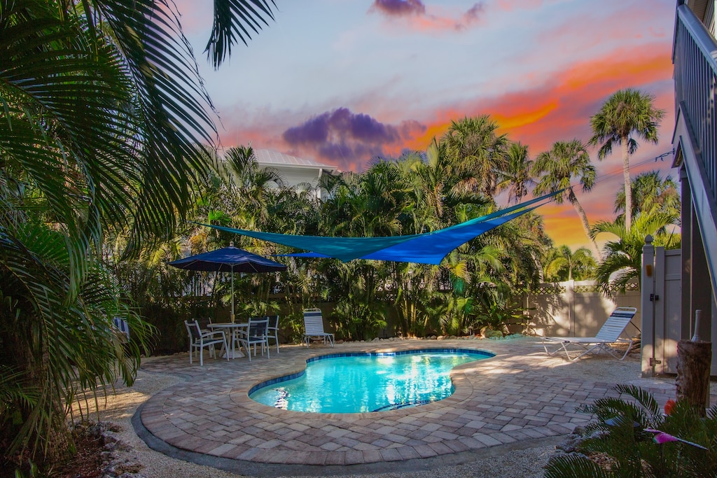 Private pool with shade sail and outdoor dining
