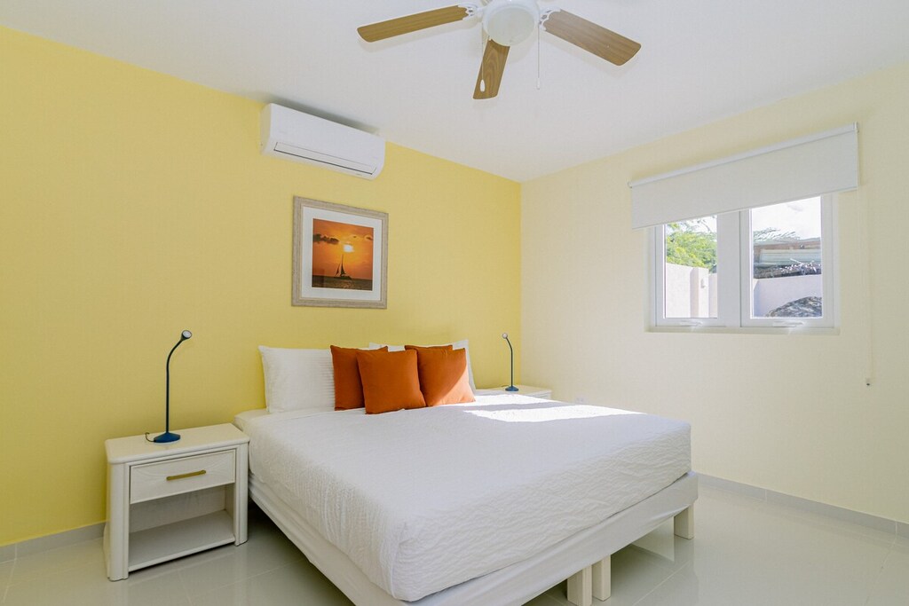Captivating Bedroom of the 4BR Home in Noord Aruba - Modern bedroom with sleek design and ample natural light - Minimalist decor, creating a clean and uncluttered sleeping space - Seamless blend of comfort, aesthetics, and functionality
