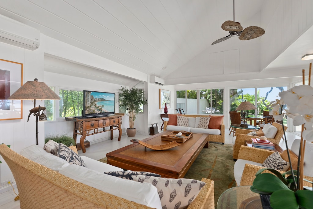 Unwind in this airy tropical living room where natural wicker and rich wood blend beneath soaring beamed ceilings and gentle ceiling fans.