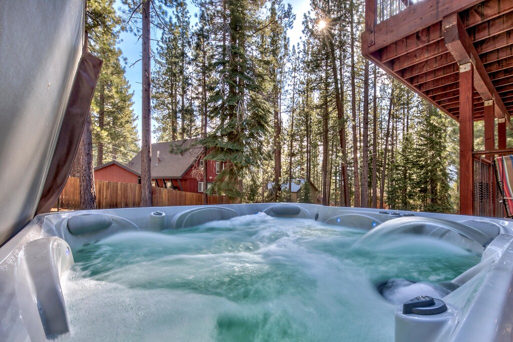Soak in your private hot tub surrounded by towering pines, where warm bubbling waters meet crisp mountain air for pure relaxation.